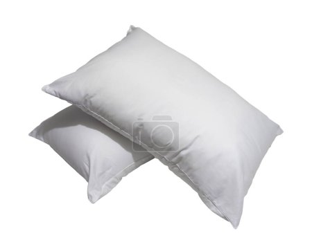 White pillows in stack after guest's use at hotel or resort room are isolated on white background with clipping path. Concept of confortable and happy sleep in daily life