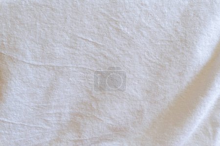 Crumpled or wrinkled white towel background texture was taken with soft natural light used for clothing background texture.