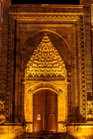 beleuchtete Zwillingsminarette des historischen Minaretts Cifte Minareli Medrese bei Nacht oder Twin Minaret Madrasa. Close Up.