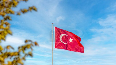 Turkish flag waving with pride against a backdrop of blue skies.