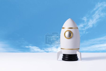 Toy rocket of spaceman. Space shuttle on table over blue background with copy space. Kids dream about future space flying concept.