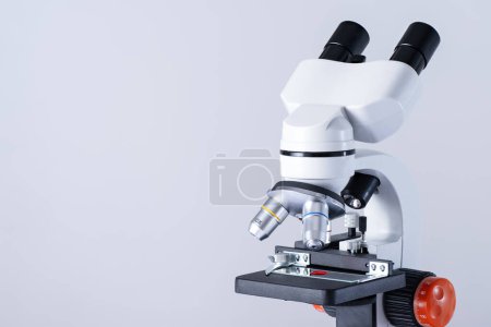 Microscope sur fond blanc avec espace de copie. Un échantillon de sang sur un verre au microscope. Recherche sur les tests VIH.