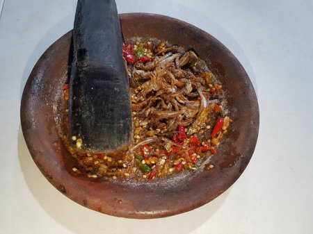 Hot spici sauce from chilli peppers, shallots, garlic, various spices and tomatoes  in bowl on wooden table. red hot sweet chilli sauce over old wooden background. 