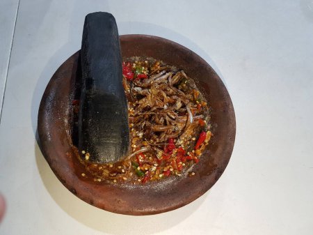 Hot spici sauce from chilli peppers, shallots, garlic, various spices and tomatoes  in bowl on wooden table. red hot sweet chilli sauce over old wooden background. 