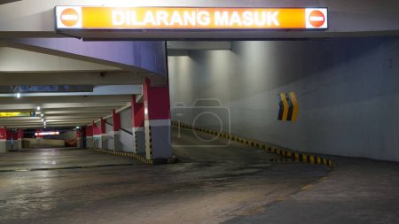 Photo for Selective focus parking sign symbol, no entry and exit directions in the basement parking of a building - Royalty Free Image