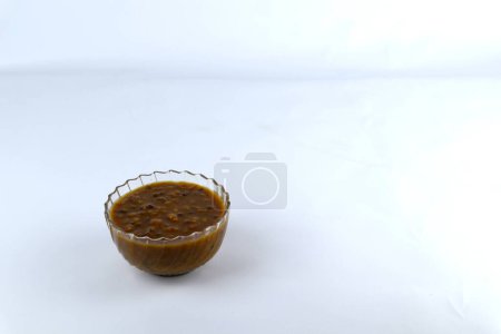 Téléchargez les photos : Un bol de porridge aux haricots verts isolé sur un fond blanc. un dessert typiquement indonésien à base de haricots verts cuits avec du lait de coco et du sucre de palme. - en image libre de droit