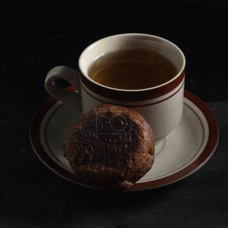 Photo for Apang bale cake or Apang bakar, and a cup of tea isolated on black background. Indonesian cake - Royalty Free Image