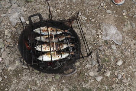 Photo for The process of making grilled fish that is burned over coconut shell coals - Royalty Free Image