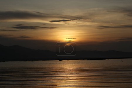 Photo for A sunset over the water with mountains in the background - Royalty Free Image