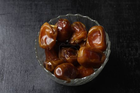Photo for Bowl of dried dates isolated on black background - Royalty Free Image