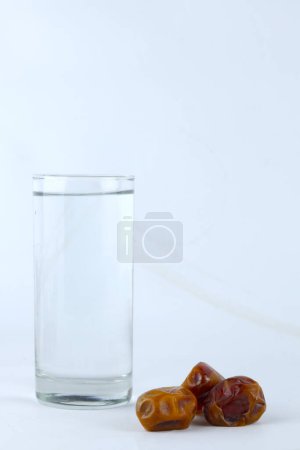 Téléchargez les photos : Dates et un verre d'eau isolé sur fond blanc - en image libre de droit