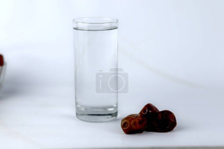 Photo for Dates and a glass of water isolated on a white background - Royalty Free Image