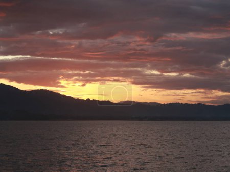Photo for Sunset Over the Lake with Mountains and Clouds in the Background - Royalty Free Image