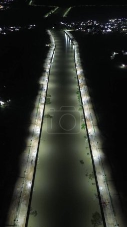 Vista aérea de un camino en medio del río por la noche