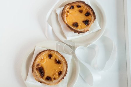 Pastel de Nata, a traditional sweet from Portuguese cuisine. Small crunchy puff pastry pies and a cream made with eggs. Often tasted and accompanied with coffee. Top view