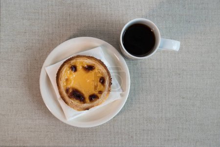 Pastel de Nata, a traditional sweet from Portuguese cuisine. Small crunchy puff pastry pies and a cream made with eggs. Often tasted and accompanied with coffee. Top view