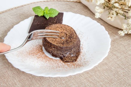 "Petit gateau "delicioso postre de chocolate, torta esponjosa con crema de chocolate derretido en el interior. Servido y listo para comer pastel casero en un plato blanco.