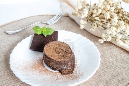 "Petit gateau" delicious chocolate dessert, fluffy cake with melted chocolate cream inside. Served and ready-to-eat homemade cake on a white plate.