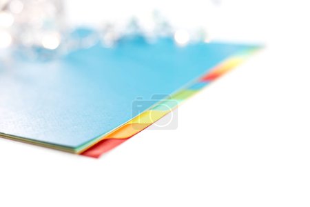 Colored sheets with tabs placed on a white background, selective focus. Copy space.