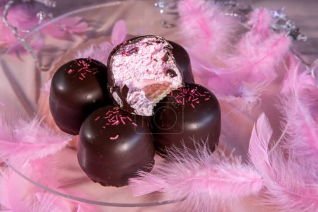 Sponge marshmallow candy covered in chocolate and vanilla wafer underneath, on a pink background.