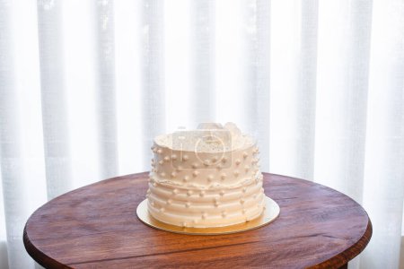White party cake with white icing and pearls, cake design. Handmade cake made for a special celebratory occasion. Copy space