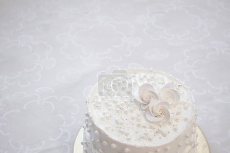 White party cake with white icing and pearls, cake design. Handmade cake made for a special celebratory occasion. Copy space
