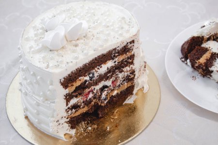 Tarta de fiesta blanca con perlas y glaseado blanco y relleno de fruta roja y chocolate, diseño de pastel. Pastel hecho a mano para una ocasión especial de celebración.