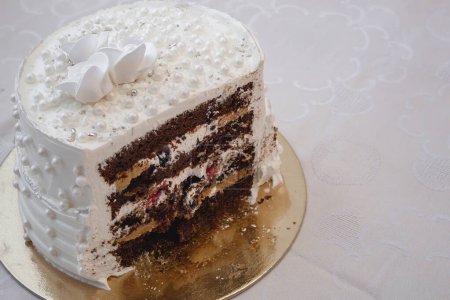 Tarta de fiesta blanca con perlas y glaseado blanco y relleno de fruta roja y chocolate, diseño de pastel. Pastel hecho a mano para una ocasión especial de celebración.