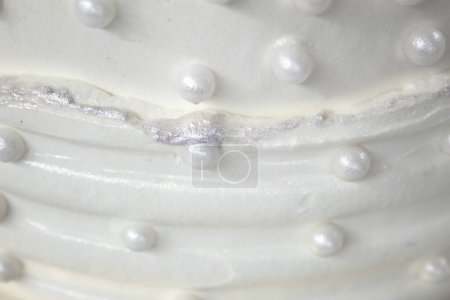 Gâteau de fête blanc avec glaçage blanc et perles, conception de gâteau. Gâteau fait à la main pour une occasion spéciale de célébration. Détails particuliers.