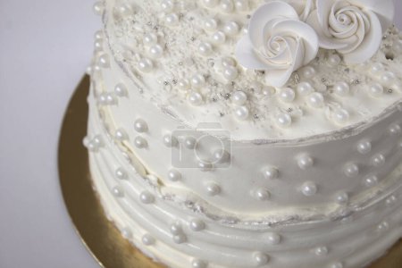 White party cake with white icing and pearls, cake design. Handmade cake made for a special celebratory occasion. Special details.