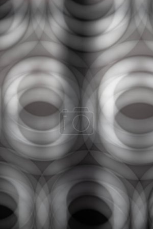 Abstraktes Bild in Grautönen mit mehreren verschwommenen Kreisen, das das Gefühl von Tiefe erzeugt. Tapeten, Muster, Hintergründe.