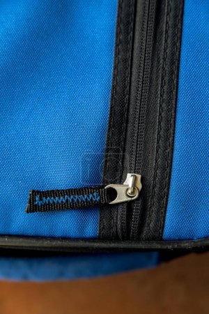 Detalle de un objeto de tela azul con cremallera negra. Primer plano y vista superior.