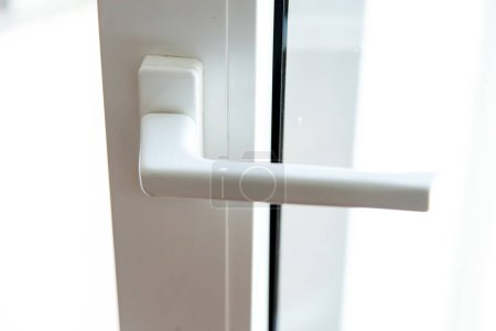 White interior handle in pvc or plastic material. Detail of a door.