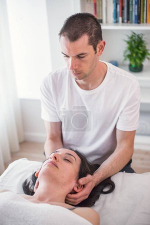 Téléchargez les photos : Thérapeute faire une session avec massage localisé dans la région du crâne avec l'application de petites pressions douces pour améliorer l'état de santé du patient. Thérapie craniosacrée. - en image libre de droit