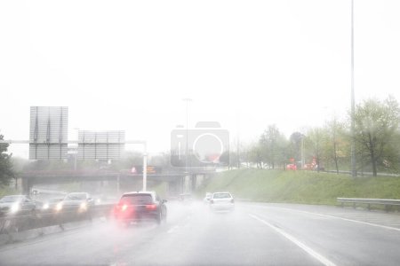 Bild des Abschnitts der internen Umgehungsstraße, VCI, Porto, Portugal. Lokaler Verkehr während eines Schlechtwettertages mit starkem Regen. Infotafel "Bei Regen, mäßige Geschwindigkeit".