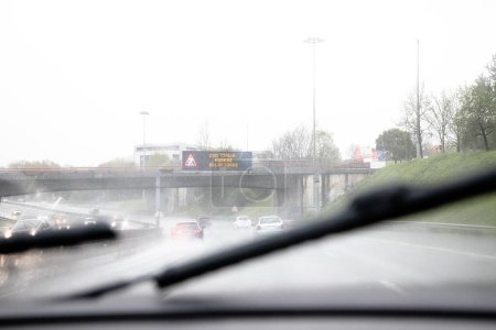 Bild des Abschnitts der internen Umgehungsstraße, VCI, Porto, Portugal. Lokaler Verkehr während eines Schlechtwettertages mit starkem Regen. Infotafel "Bei Regen, mäßige Geschwindigkeit".