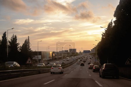 Tráfico de vehículos al final del día con la puesta de sol en el horizonte en el cinturón interior, VCI, Oporto, Portugal.