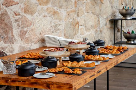 A beautifully arranged buffet table showcasing a variety of appetizers and snacks, including meat dishes, fried pastries, ready for guests to enjoy a delightful meal.
