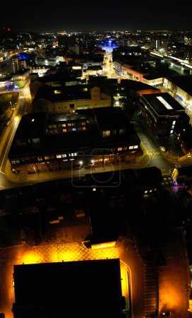 Foto de UK, INGLATERRA, LUTON - 20 DE ENERO DE 2023: Vista iluminada de la ciudad inglesa durante la noche. Vista aérea de la carretera y el tráfico con negocios en la noche. Vista de la cámara de Drone - Imagen libre de derechos