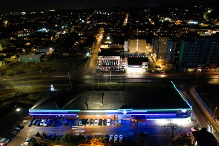 Foto de UK, INGLATERRA, LUTON - 20 DE ENERO DE 2023: Vista iluminada de la ciudad inglesa durante la noche. Vista aérea de la carretera y el tráfico con negocios en la noche. Vista de la cámara de Drone - Imagen libre de derechos
