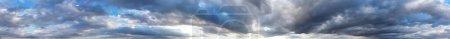 Téléchargez les photos : Vue panoramique des nuages dramatiques dans le ciel bleu - en image libre de droit