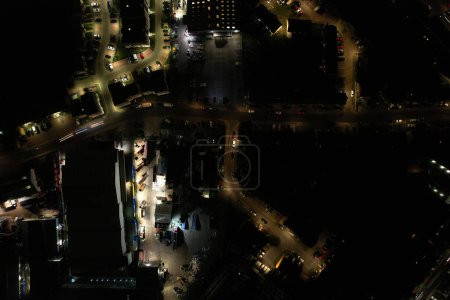 Téléchargez les photos : UK, ANGLETERRE, LUTON - 20 JANVIER 2023 : Vue Illuminée English City During Night. Vue aérienne de la route et de la circulation avec les entreprises la nuit. Vue de la caméra du drone - en image libre de droit