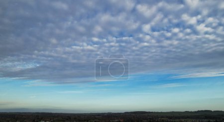 Téléchargez les photos : Vue à grand angle du ciel bleu et des couleurs des nuages au-dessus de la Grande-Bretagne pendant le coucher du soleil - en image libre de droit