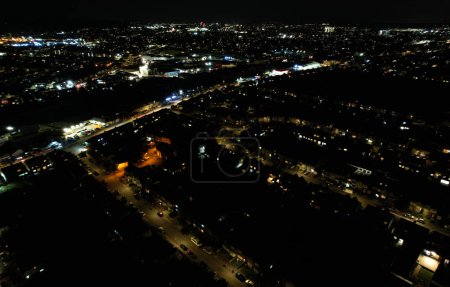 Photo for UK, ENGLAND, LUTON - 20TH JANUARY 2023: Illuminated View English City During Night. Aerial View of Road and Traffic with Businesses at Night. Drone's Camera View - Royalty Free Image