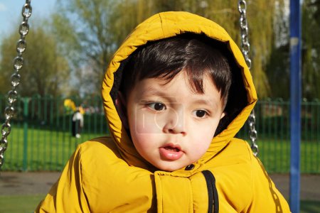 Téléchargez les photos : Mignon asiatique pakistanais bébé profiter de la belle journée ensoleillée à Lewsey Public Park - en image libre de droit