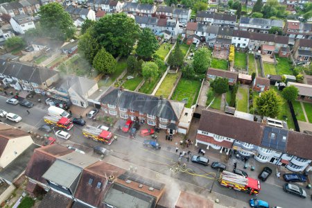 Téléchargez les photos : Caméra de drone à angle élevé des pompiers et de l'équipe de sauvetage le long de la police aussi bien. Le feu a commencé à la maison Vers 17h40. Image prise le 19 mai 2023 à Luton en Angleterre. - en image libre de droit