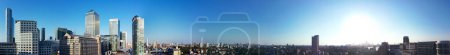 Téléchargez les photos : Vue panoramique à angle élevé des bâtiments de Canary Wharf au centre de Londres City of England Grande-Bretagne. La séquence a été capturée avec la caméra du drone à basse altitude le 08-juin-2023 lors de la journée chaude par temps clair. - en image libre de droit