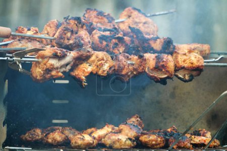 Foto de Cocinar carne en la parrilla. carne de barbacoa en las torres. Día de barbacoa en casa - Imagen libre de derechos
