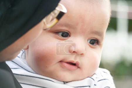Photo for Cute Asian Pakistani Baby Boy is Posing in the Home Garden During Cloudy Day over Luton, England UK. Image Was Captured on July 23rd, 2023 - Royalty Free Image