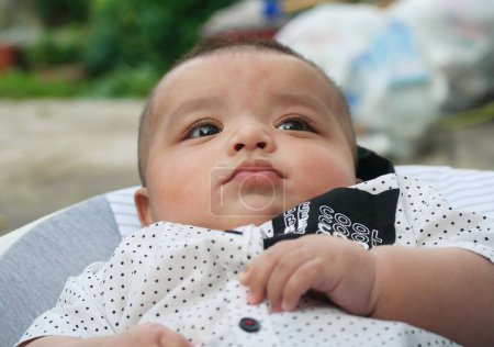 Photo for Close Up Shot of Cute Asian Pakistani 4 Months Old Baby Boy, Who is Enjoying at Home Garden at Luton City of England UK. Image Was Captured on July 23rd, 2023 - Royalty Free Image